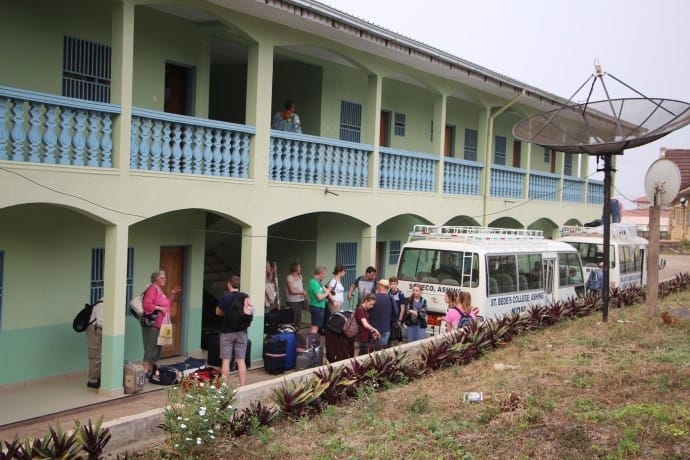 Travelers in front of a green hotel in Cameroon
